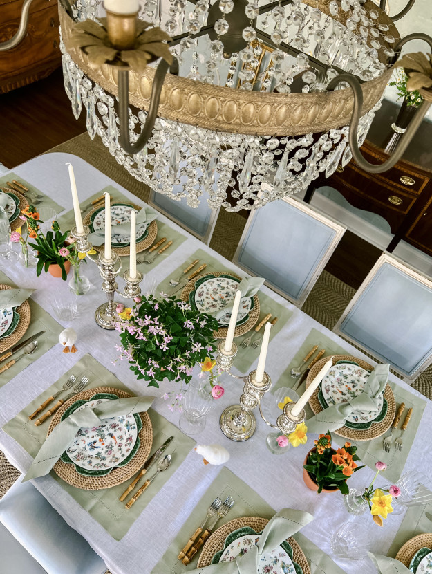 A refined easter tablescape with a floral centerpiece, candlesticks, and subtle spring accents.